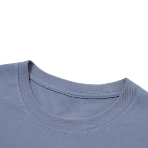 Close-up view of the ribbed collar on a blue-grey cotton t-shirt against a white background.