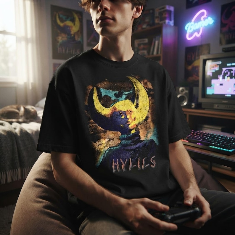 A person wearing the Hylics indie game t-shirt in a cozy gaming room setting.