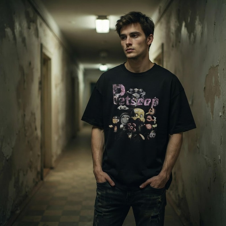 Model wearing the black Petscop bootleg tee in an atmospheric hallway showing the oversized relaxed fit and chest graphic.