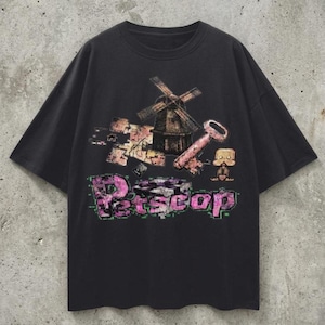 May include: Black t-shirt with a graphic design featuring a windmill, key, and a small figure. The word "Petscop" is printed in a pink and green glitch font. The shirt has short sleeves and a crew neck.