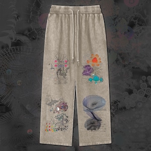 Könnte beinhalten: Beige Jogginghose mit Kordelzugbund und weiten Beinen. Die Hose hat bunte, abstrakte Blumen- und geometrische Designs auf der Vorderseite aufgedruckt. Die Designs umfassen Farbtöne von Rosa, Orange, Lila, Blau und Grün. Der Gesamtstil ist lässig und künstlerisch.