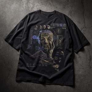 May include: Black t-shirt featuring a surreal graphic design. The design includes a human face with a third eye, celestial bodies, and Japanese text. The words "Living Information" are also present. The shirt has short sleeves and a crew neck.
