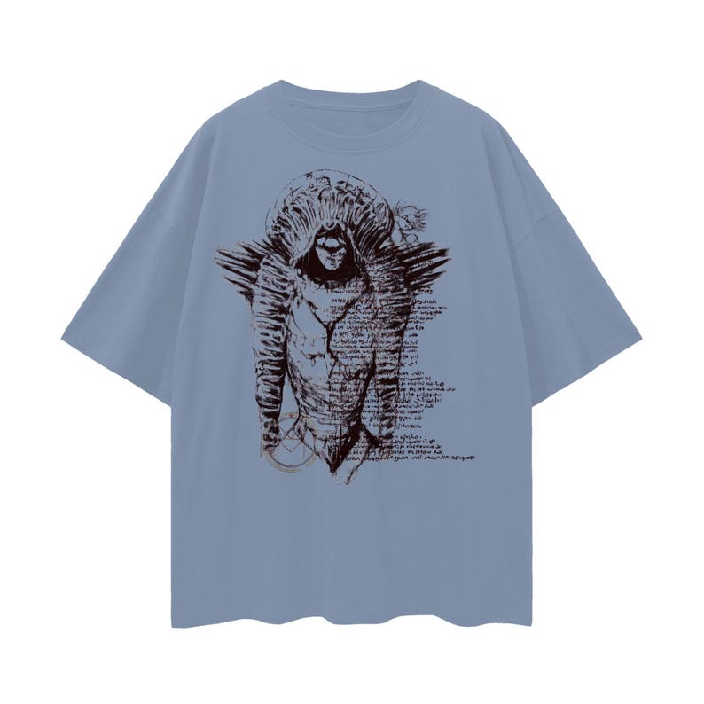 May include: A pale blue t-shirt with a brown illustration of a hooded figure with wings and script. The graphic is on the front. The shirt has short sleeves and a crew neck.