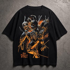 Puede incluir: Camiseta negra con un gráfico naranja y negro de una figura esquelética con un cráneo y elementos robóticos. El texto "Five Nights at Freddy's" está impreso en naranja, con una fuente estilizada.