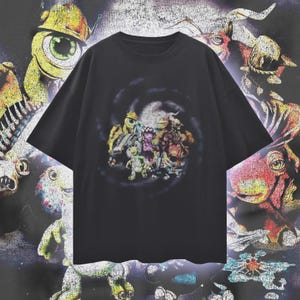 Puede incluir: Camiseta negra con un gráfico colorido de varios personajes de dibujos animados. El diseño está centrado en la camiseta y sobre un fondo oscuro. La camiseta tiene mangas cortas y cuello redondo.