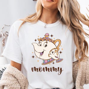 May include: White t-shirt with a cartoon image of Mrs. Potts and Chip from Beauty and the Beast. The text "mommy" is printed below the image.