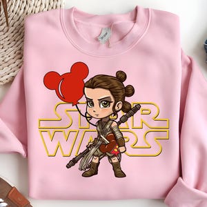 Star Wars shirt featuring fan-favorite characters like Darth Vader, Baby Yoda, Chewbacca, and Han Solo with fun Mickey head accents. This soft, unisex tee or sweatshirt is perfect for Disney trips, Star Wars Day, or matching family outfits. A playful mix of galaxy and Disney magic, ideal for park hopping, themed parties, or gifting to fans of the Mandalorian and the whole Star Wars crew.