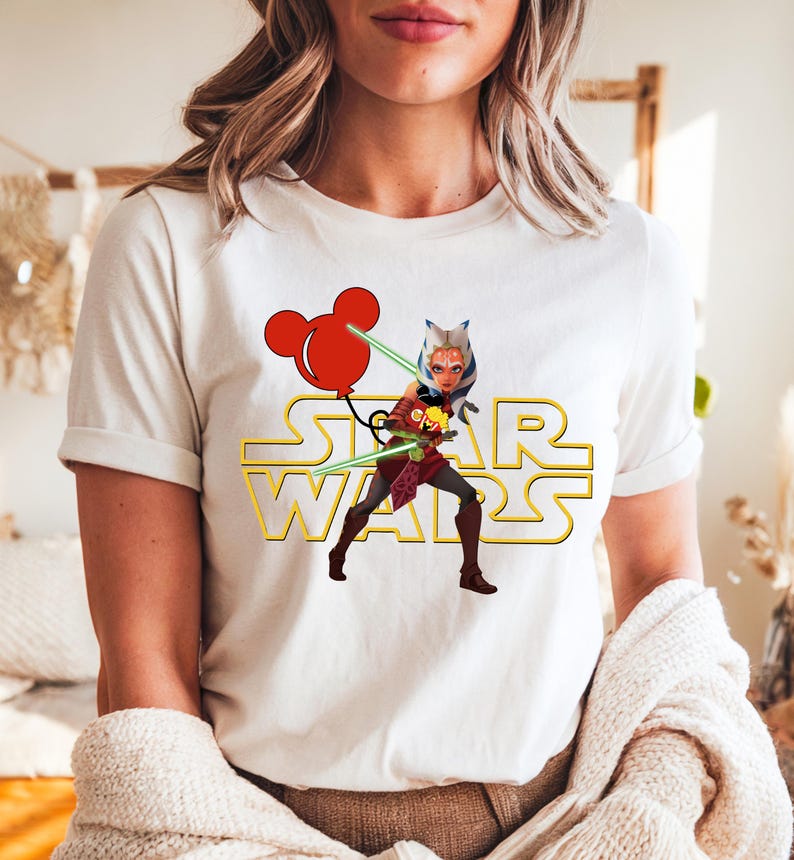 Star Wars shirt featuring fan-favorite characters like Darth Vader, Baby Yoda, Chewbacca, and Han Solo with fun Mickey head accents. This soft, unisex tee or sweatshirt is perfect for Disney trips, Star Wars Day, or matching family outfits. A playful mix of galaxy and Disney magic, ideal for park hopping, themed parties, or gifting to fans of the Mandalorian and the whole Star Wars crew.