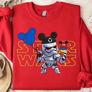 Star Wars shirt featuring fan-favorite characters like Darth Vader, Baby Yoda, Chewbacca, and Han Solo with fun Mickey head accents. This soft, unisex tee or sweatshirt is perfect for Disney trips, Star Wars Day, or matching family outfits. A playful mix of galaxy and Disney magic, ideal for park hopping, themed parties, or gifting to fans of the Mandalorian and the whole Star Wars crew.