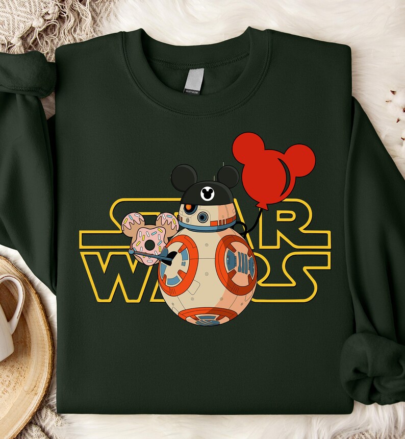 Star Wars shirt featuring fan-favorite characters like Darth Vader, Baby Yoda, Chewbacca, and Han Solo with fun Mickey head accents. This soft, unisex tee or sweatshirt is perfect for Disney trips, Star Wars Day, or matching family outfits. A playful mix of galaxy and Disney magic, ideal for park hopping, themed parties, or gifting to fans of the Mandalorian and the whole Star Wars crew.
