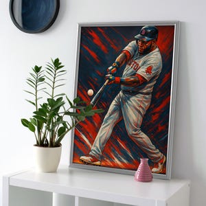 May include: A framed baseball art print featuring a player in a batting stance. The artwork uses red, blue, and white colors. The player is wearing a baseball uniform. A baseball is in mid-air, and the background has abstract brushstrokes.