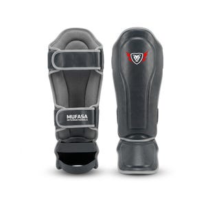 May include: Pair of black and gray shin guards with the text "MUFASA INTERNATIONALS". The guards have a padded interior and adjustable straps. A logo of a lion's head with red wings is on one guard.