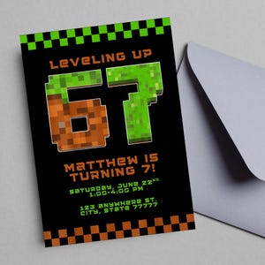 以下が含まれることがあります： 黒色の招待状カード。茶色と緑色のピクセル化された「67」、テキスト「LEVELING UP」と「MATTHEW IS TURNING 7！」、イベントの詳細が記載されています。灰色の封筒が含まれています。招待状はビデオゲームをテーマにデザインされています。