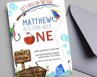 Peut inclure: Une invitation blanche sur le thème de la pêche. La carte présente une canne à pêche, un flotteur et un bateau. Le texte comprend "Let's Reel in the Fun", "Matthew is O-Fish-ally One" et les détails de l'événement. Une enveloppe grise est à droite.