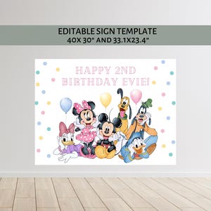 Puede incluir: Un letrero blanco con el texto "HAPPY 2ND BIRTHDAY EVIE!" con los personajes de dibujos animados Mickey Mouse, Minnie Mouse, Donald Duck, Daisy Duck, Goofy y Pluto. El letrero mide 101,6x76,2 cm y 84,1x59,4 cm.