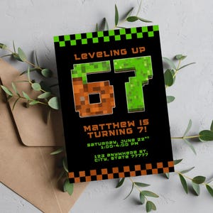 以下が含まれることがあります： 「Leveling Up 67」と書かれた、ピクセル化された緑と茶色の数字とテキストが特徴の黒い招待状。カードには「Matthew is turning 7!」というテキストとイベントの詳細も含まれています。