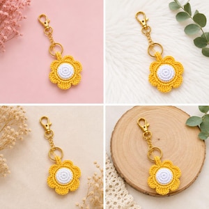 May include: A crochet flower keychain featuring a bright yellow petal border and a white circular center. The flower is attached to a gold-toned metal lobster clasp and a short chain link, providing a secure way to attach the item to keys or bags.