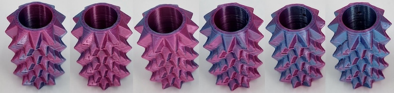 May include: Six cylindrical objects with a spiky, geometric exterior texture. Each piece features a color-shifting finish that transitions between shades of metallic purple, magenta, and blue. The items have a hollow, open-top circular opening.