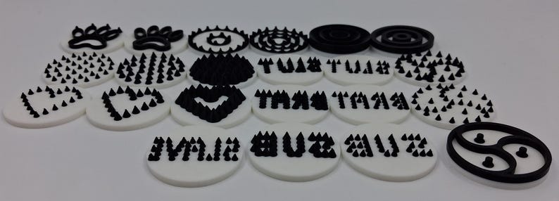 May include: A collection of white and black decorative elements. The designs include paw prints, hearts, geometric patterns, and text. The text includes the words "TA TA" and "BUZZ ME".