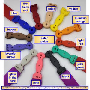 May include: A collection of paint scrapers in various colors, including blue, red, yellow, and black. The handles are ergonomically designed, and the blades are rectangular. The image includes a color guide and text indicating color variations may occur.