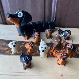 Chaveiros e brinquedos antiestresse articulados em formato de cachorro salsicha Dachshund, impressos em 3D.