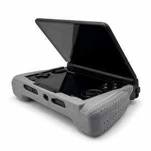 May include: A black handheld gaming console featuring a clamshell design with a top screen and a bottom control panel. The device is encased in a textured gray protective grip cover with perforated side panels and precise cutouts for ports.