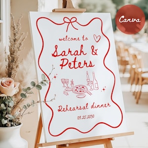 May include: A white sign on an easel with red text and illustrations. The sign reads "welcome to Sarah & Peters Rehearsal dinner 09.25.2030". A red circle with the word "Canva" is in the upper right corner.