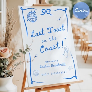 Könnte beinhalten: Ein weißes Schild mit blauer Beschriftung, auf dem "Last Toast on the Coast!" steht.  Willkommen zum Junggesellinnenabschied von Amelia. Lasst uns feiern!  Auf dem Schild sind eine blaue Discokugel, zwei blaue Champagnergläser, eine blaue Muschel und ein blauer Seestern zu sehen.