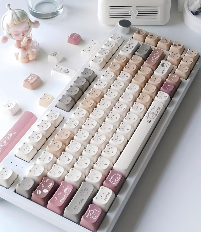 Puede incluir: Un teclado mec&aacute;nico blanco con teclas personalizadas en varios colores neutros, incluyendo blanco, beige y rosa. Las teclas presentan dise&ntilde;os de osos y caf&eacute;, con algunas teclas etiquetadas como "Tab", "Caps", "shift", "alt" y "coffee".