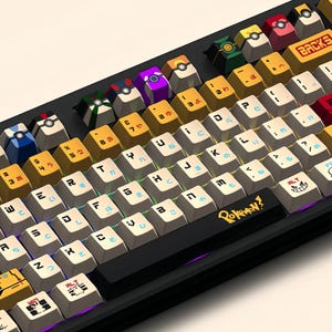 Puede incluir: Un teclado mec&aacute;nico negro con teclas blancas y teclas de colores con personajes de Pokemon. El teclado tiene una disposici&oacute;n japonesa con el texto "Pokemon?" en la barra espaciadora.