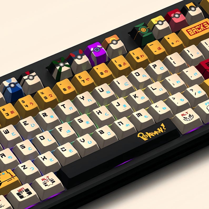 Puede incluir: Un teclado mec&aacute;nico negro con teclas blancas y teclas de colores con personajes de Pokemon. El teclado tiene una disposici&oacute;n japonesa con el texto "Pokemon?" en la barra espaciadora.