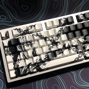May include: A white mechanical keyboard with black keycaps. The keyboard has a custom design featuring a black and white illustration of a woman with chains.