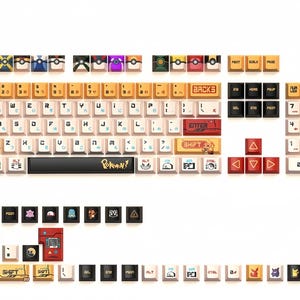Puede incluir: Un teclado con tem&aacute;tica de Pokemon. Las teclas son blancas con letras negras y presentan varios personajes de Pokemon. El teclado tambi&eacute;n incluye una barra espaciadora con la palabra "Pokemon" impresa en ella.