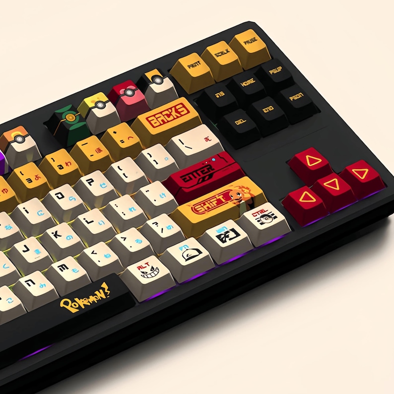 Puede incluir: Un teclado negro con teclas personalizadas que presentan personajes de Pok&eacute;mon. Las teclas son amarillas, rojas y blancas con varios dise&ntilde;os de Pok&eacute;mon. El teclado tiene una disposici&oacute;n japonesa con la palabra "Pokemon!" impresa en la barra espaciadora.