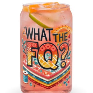 Puede incluir: Una lata de vidrio rosa con un diseño colorido y el texto "WHAT THE FQ?" impreso en ella. La lata está llena de una bebida rosa y hielo.