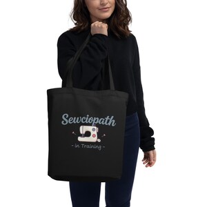 May include: Black tote bag with a white sewing machine graphic and the text "Sewciopath - in Training".