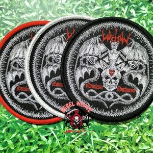 May include: Three circular embroidered patches featuring a black background with a white winged demon figure sitting atop a skull. The design includes red text reading "Lathan" and "Lawless Darkness" with a red border on one and white on others.