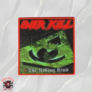 Puede incluir: Un parche bordado cuadrado con el texto rojo OVER KILL en la parte superior y el texto blanco The Killing Kind en la parte inferior. El centro muestra un símbolo de pica verde sobre un fondo negro, rodeado por un borde cosido rojo.