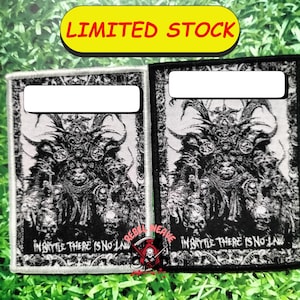 May include: Two rectangular fabric patches featuring a black and white detailed illustration of a horned, armored figure surrounded by skulls. The text "IN BATTLE THERE IS NO LAW" is printed at the bottom of each patch in a bold, stylized font.