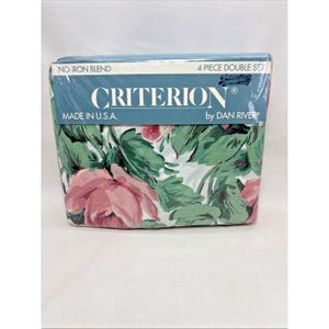May include: A packaged double bed sheet set with a floral pattern. The sheets are in a plastic wrap. The floral pattern includes pink roses and green leaves on a white background. The packaging reads "CRITERION" and "MADE IN U.S.A."
