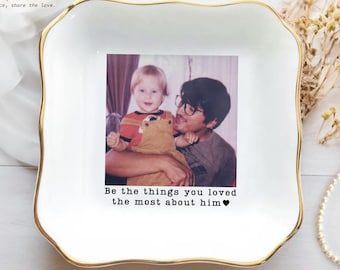May include: A square white ceramic trinket dish with a gold-painted scalloped rim. The centre features a printed photograph of a child in overalls being held by an adult, with the text "Be the things you loved the most about him♥" below.