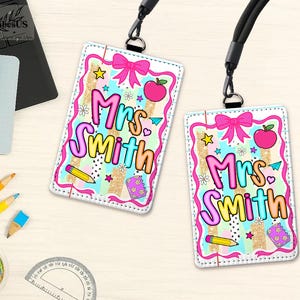 May include: Two personalized teacher ID badges with the name "Mrs. Smith" in colorful bubble letters. Each badge features a pink bow, apple, stars, and pencil design. The badges are attached to black lanyards.