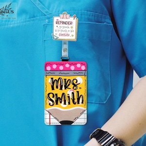 K&ouml;nnte beinhalten: Ein Namensschild f&uuml;r Lehrer mit einem Bleistift-Design. Das Abzeichen ist gelb mit dem Namen "MRS. SMITH" in Schwarz und Wei&szlig;. Ein rosa-wei&szlig; gepunkteter Rand bedeckt den Bleistift. Eine Erinnerungsnotiz ist angebracht.