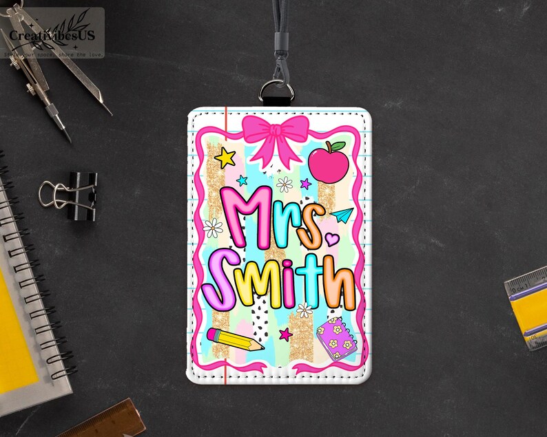 May include: A colorful teacher ID badge with the name "Mrs. Smith" in bubble letters. The badge features a pink bow, apple, stars, and pencil graphics. The badge is on a black lanyard.