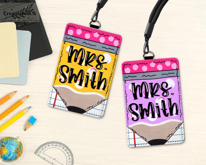 K&ouml;nnte beinhalten: Zwei personalisierte Lehrer-Ausweishalter mit Bleistift-Design. Einer ist gelb mit rosa Punkten, der andere ist lila mit rosa Punkten. Beide tragen den Namen "Mrs. Smith" in schwarzer Schrift.