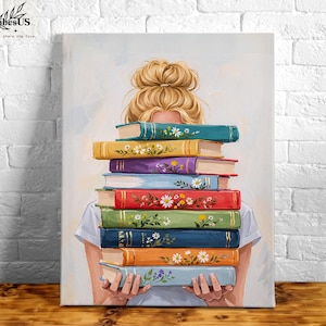 May include: A canvas print featuring a woman holding a stack of colorful books. The books have floral designs and are in various colors, including blue, yellow, red, and green. The woman's blonde hair is styled in a bun.