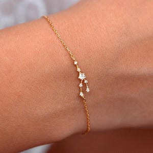 May include: A delicate gold chain bracelet with a constellation design featuring small clear stones.