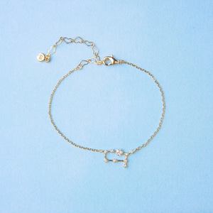 Puede incluir: Un brazalete de cadena dorada con un dije de constelaci&oacute;n G&eacute;minis hecho de peque&ntilde;os cristales transparentes.