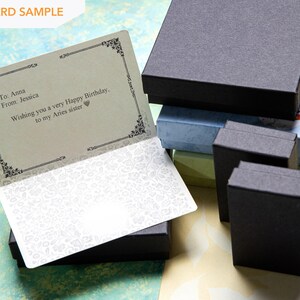 May include: A gift card sample with a black and white patterned border. The card has a message that reads "To Anna From: Jessica Wishing you a very Happy Birthday. to my Aries sister".