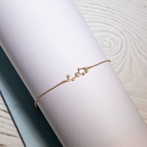 May include: A delicate gold chain bracelet with a constellation design featuring small sparkling stones.